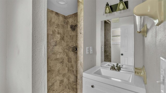 bathroom featuring vanity and tiled shower