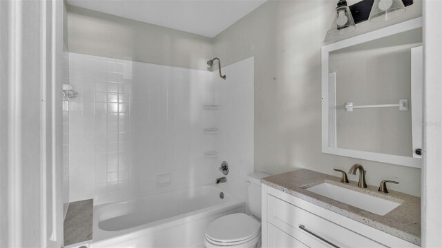 full bathroom featuring vanity, tiled shower / bath, and toilet