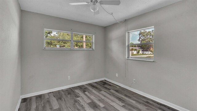 empty room with ceiling fan, wood-type flooring, and a healthy amount of sunlight