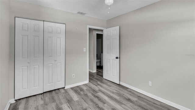 unfurnished bedroom featuring a closet and wood-type flooring