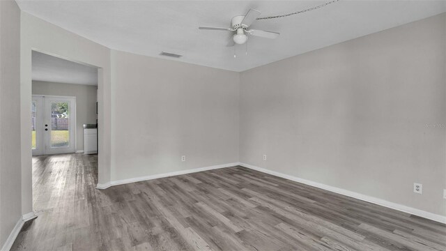 spare room featuring french doors, hardwood / wood-style floors, and ceiling fan