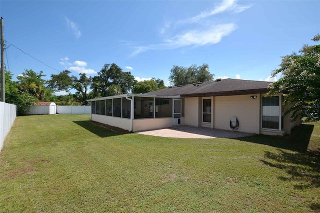 rear view of property with a sunroom, a yard, and a patio