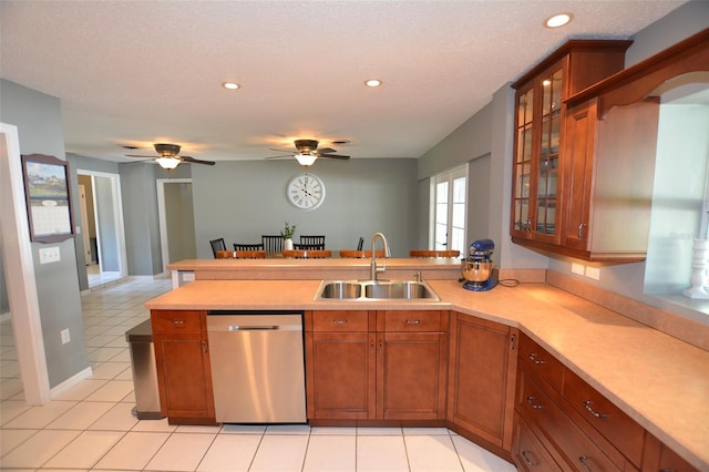 kitchen featuring kitchen peninsula, stainless steel dishwasher, ceiling fan, sink, and light tile patterned floors