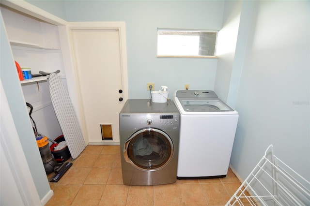 laundry area with light tile patterned floors and washing machine and dryer