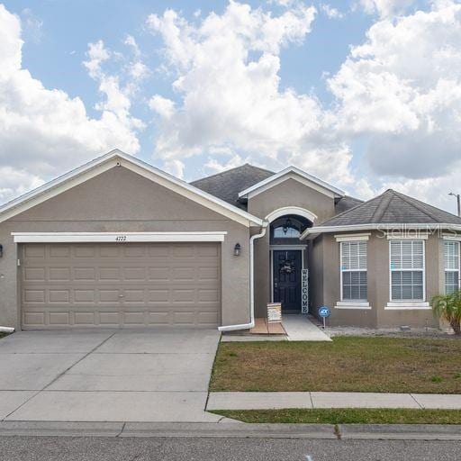 single story home featuring a garage and a front yard