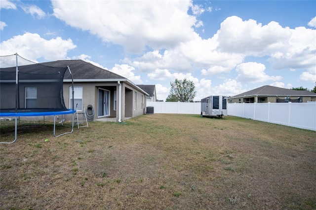 view of yard featuring a trampoline and central AC unit