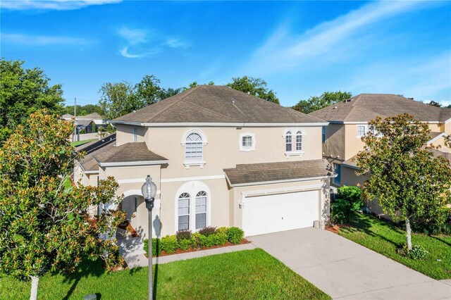 front of property with a garage and a front lawn