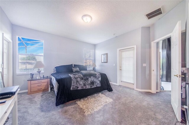 bedroom with light carpet and a textured ceiling