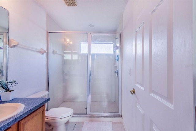 bathroom with a shower with shower door, vanity, tile patterned flooring, and toilet