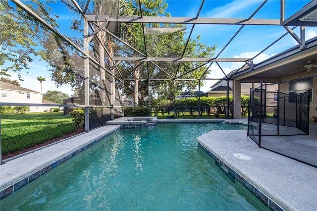 view of pool featuring an in ground hot tub, ceiling fan, a yard, and a lanai