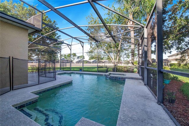 view of pool featuring an in ground hot tub, a patio, and glass enclosure