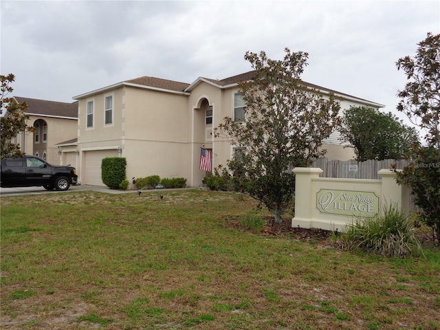 view of front of house with a garage, a front yard, concrete driveway, and stucco siding