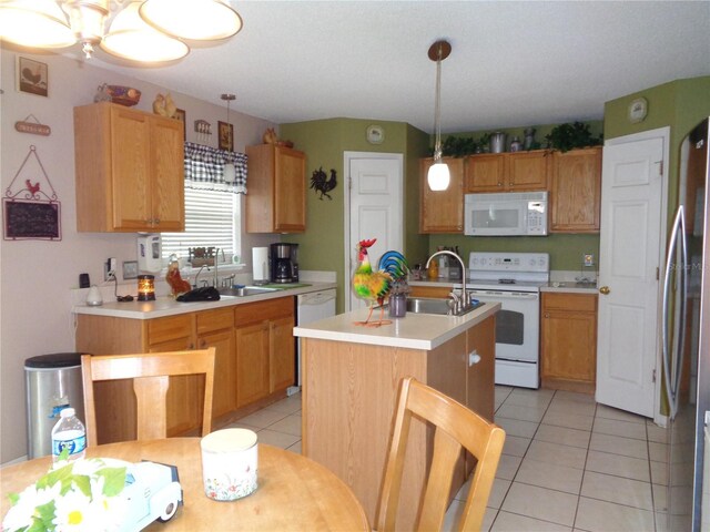 kitchen featuring a kitchen island with sink, pendant lighting, white appliances, and light tile patterned floors