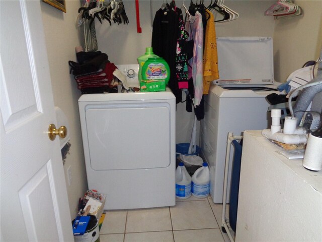 laundry room featuring washing machine and dryer and light tile patterned floors