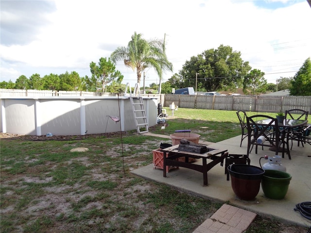 view of yard with a patio area, a fenced backyard, a fenced in pool, and outdoor dining space