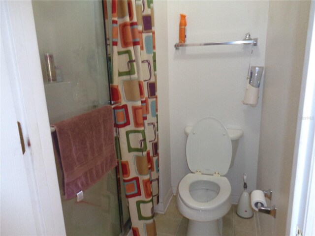 bathroom with walk in shower, tile patterned floors, and toilet