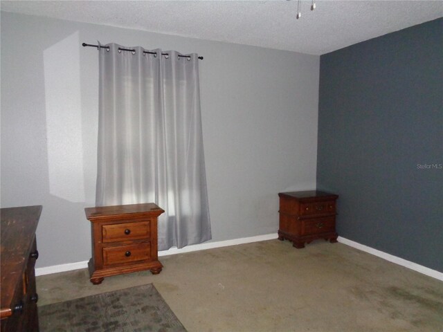 sitting room with dark carpet and a textured ceiling