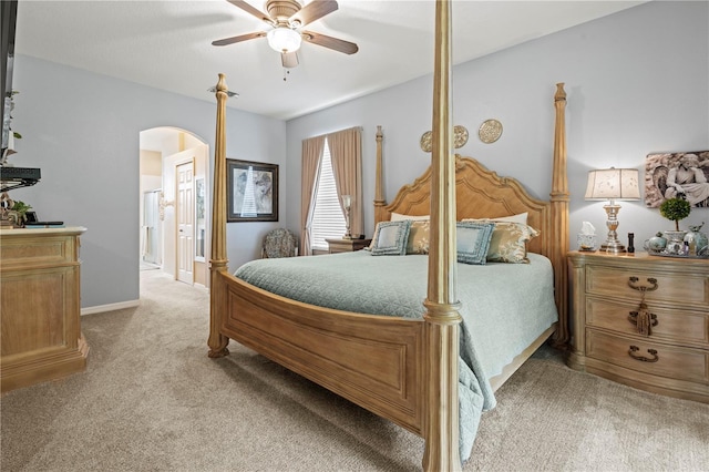 bedroom with ceiling fan, light carpet, and connected bathroom