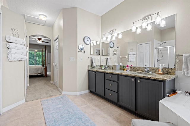 bathroom featuring separate shower and tub, vanity, ceiling fan, tile patterned floors, and a textured ceiling