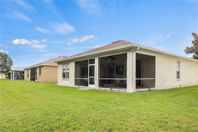 back of property featuring ceiling fan, a sunroom, and a yard