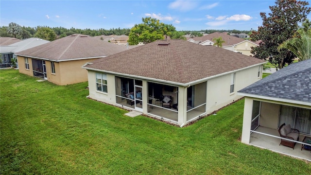 back of house featuring a yard and a sunroom