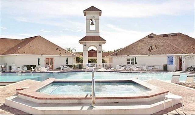 view of pool featuring a hot tub and a patio area