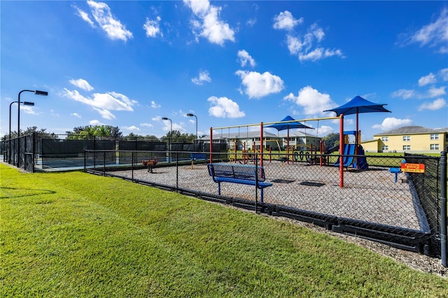 view of play area featuring tennis court and a yard