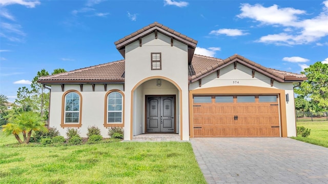 mediterranean / spanish house featuring a garage and a front yard