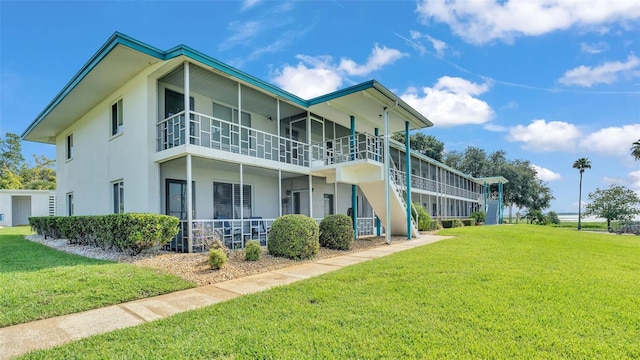 1600 W Lake Parker Dr Unit A2, Lakeland, FL 33805 - rear view of house featuring stucco siding, stairway, and a lawn