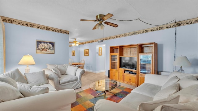 1600 W Lake Parker Dr Unit A2, Lakeland, FL 33805 - living area featuring light wood finished floors, a ceiling fan, a textured ceiling, visible vents, and baseboards