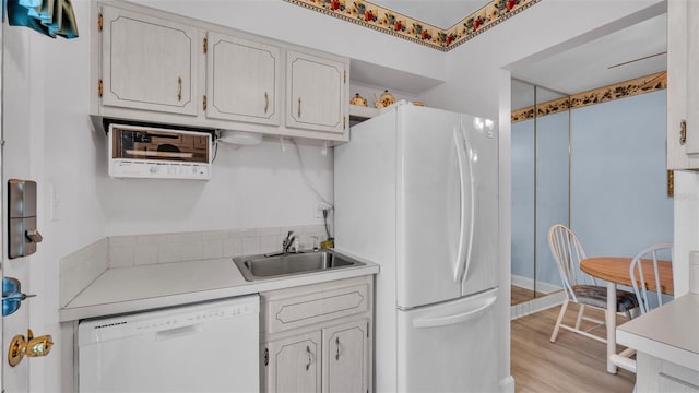 1600 W Lake Parker Dr Unit A2, Lakeland, FL 33805 - kitchen with light countertops, light wood-type flooring, a sink, and white appliances