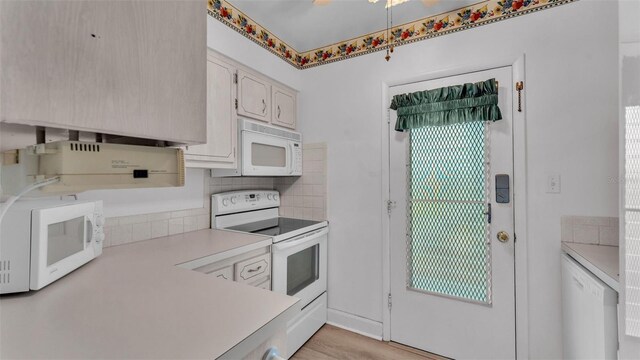 1600 W Lake Parker Dr Unit A2, Lakeland, FL 33805 - kitchen featuring light wood finished floors, decorative backsplash, white appliances, and light countertops