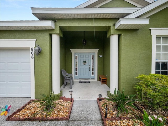 entrance to property featuring covered porch and a garage