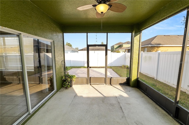 unfurnished sunroom featuring ceiling fan