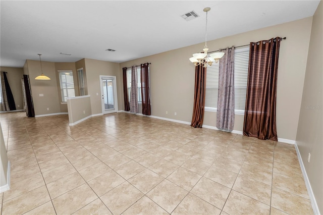 empty room with an inviting chandelier and light tile patterned floors