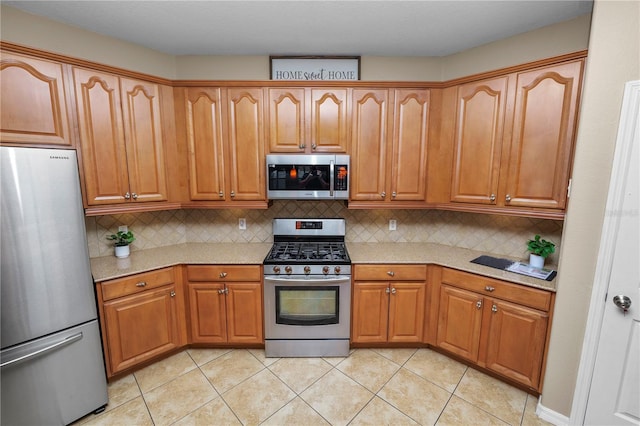 kitchen with backsplash, stainless steel appliances, and light tile patterned flooring