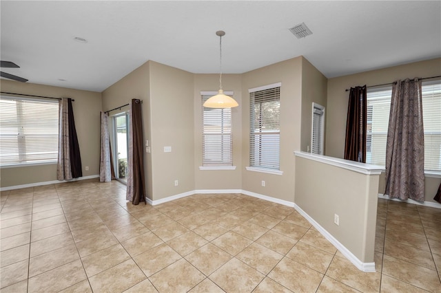 empty room with light tile patterned floors and ceiling fan