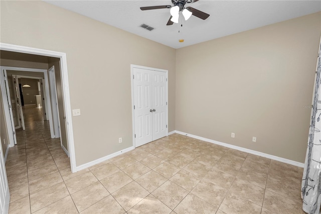 unfurnished bedroom with light tile patterned floors, a closet, and ceiling fan