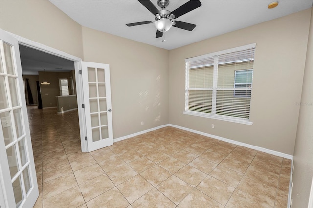 tiled empty room with ceiling fan and french doors