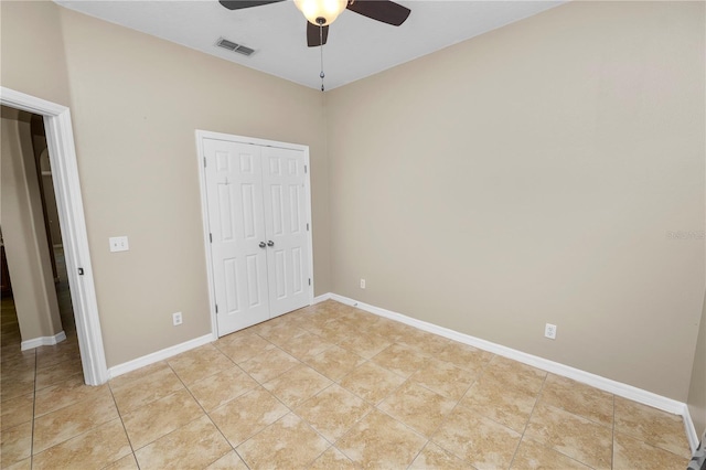 unfurnished bedroom featuring ceiling fan, a closet, and light tile patterned floors