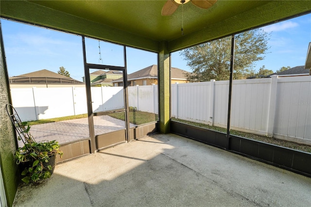 unfurnished sunroom with ceiling fan and plenty of natural light