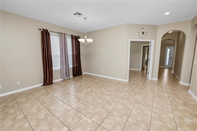 unfurnished room featuring a chandelier and light tile patterned floors