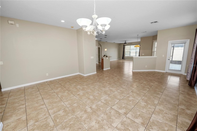 spare room featuring ceiling fan with notable chandelier, visible vents, baseboards, and light tile patterned flooring