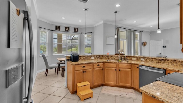 kitchen with stainless steel appliances, decorative light fixtures, light stone countertops, and sink