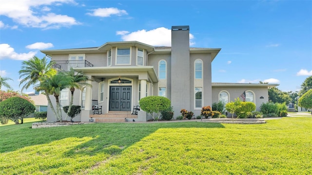 view of front of home featuring a balcony and a front yard