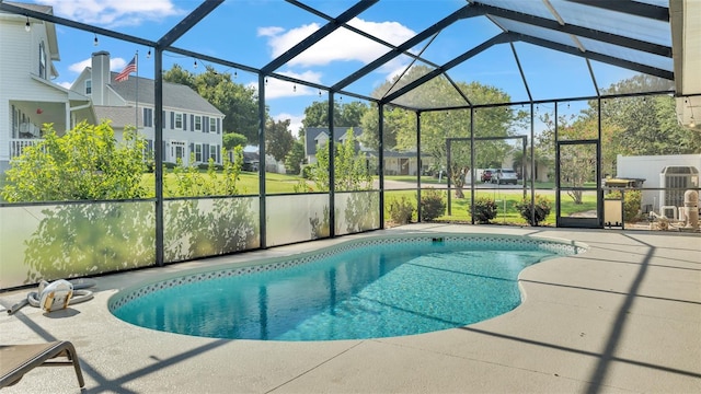 view of pool with a patio area and glass enclosure