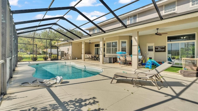 view of swimming pool featuring ceiling fan, a patio area, and glass enclosure