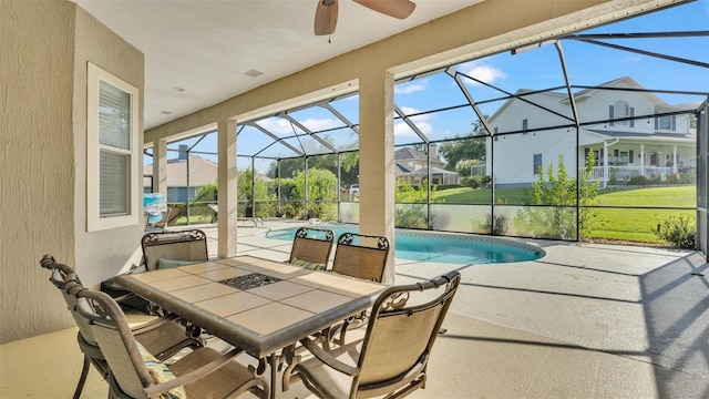 view of patio featuring ceiling fan and glass enclosure