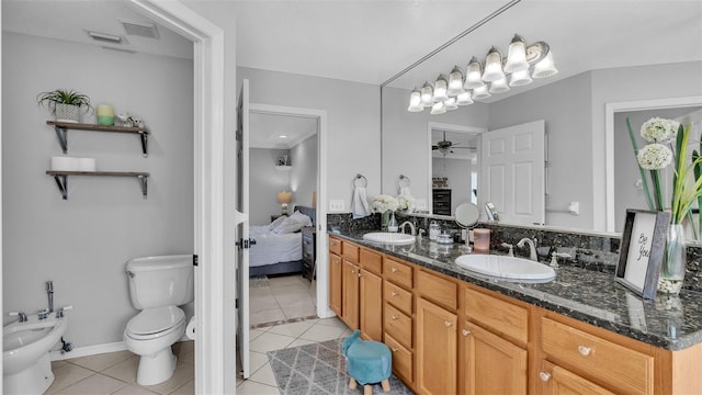 bathroom with toilet, a bidet, vanity, ceiling fan, and tile patterned flooring