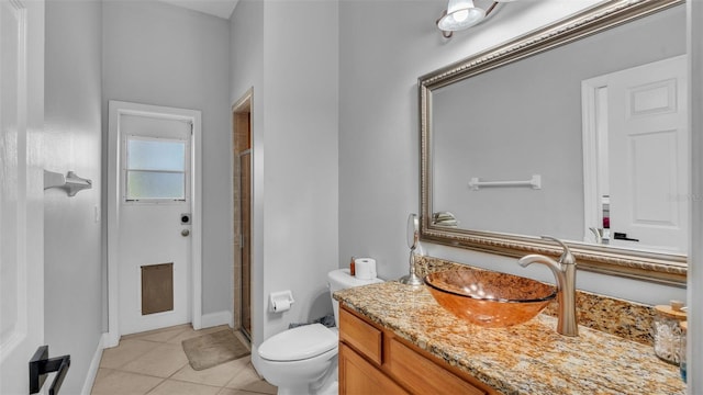 bathroom featuring vanity, a shower with shower door, tile patterned floors, and toilet